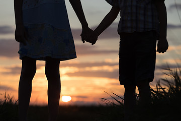 Image showing Two children standing in the park at the sunset time.