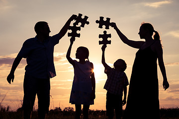 Image showing Happy family standing in the park at the sunset time.