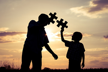 Image showing Father and son walking on the field at the sunset time. 