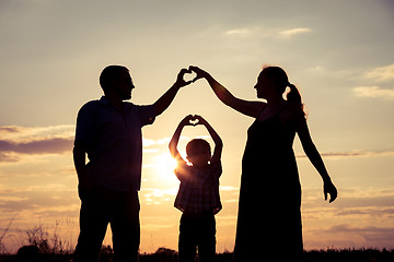 Image showing Happy family standing in the park at the sunset time.