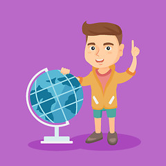 Image showing Boy standing near globe and pointing finger up.