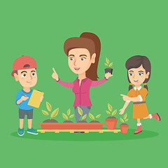 Image showing Caucasian teacher and school kids planting sprouts