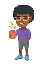 Image showing African smiling boy holding a potted plant.