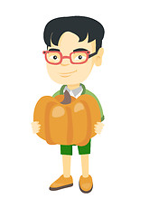 Image showing Asian boy standing with a big orange pumpkin.