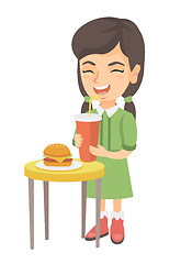 Image showing Little girl drinking soda and eating cheeseburger.