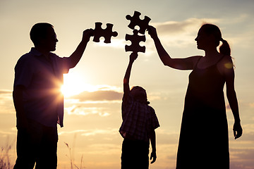 Image showing Happy family standing in the park at the sunset time.