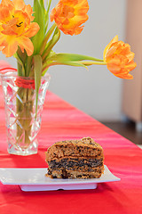 Image showing A bouquet of tulips and piece of cake on the table