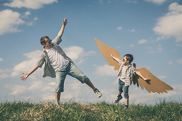 Image showing Father and son playing with cardboard toy wings