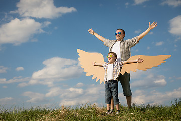 Image showing Father and son playing with cardboard toy wings