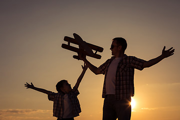 Image showing Father and son playing with cardboard toy airplane 