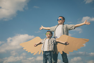 Image showing Father and son playing with cardboard toy wings