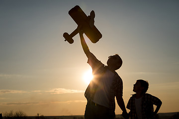 Image showing Father and son playing with cardboard toy airplane