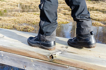 Image showing Close up of a hikers footwear on a footbridge