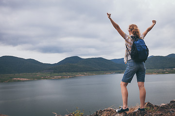 Image showing Happy woman standing near the lake at the day time.