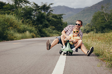 Image showing Father and daughter playing  on the road at the day time. 