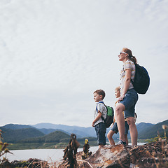 Image showing Happy family standing near the lake at the day time.