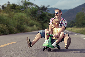 Image showing Father and daughter playing  on the road at the day time.