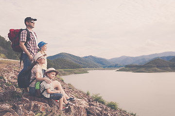 Image showing Happy family standing near the lake at the day time.