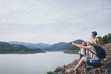 Image showing Happy family standing near the lake at the day time.