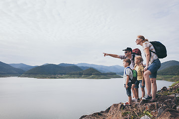 Image showing Happy family standing near the lake at the day time.