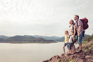 Image showing Happy family standing near the lake at the day time.