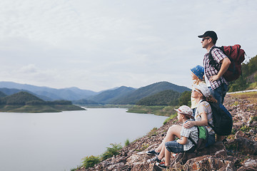 Image showing Happy family standing near the lake at the day time.