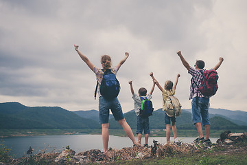 Image showing Happy family standing near the lake at the day time.