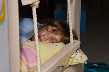 Image showing The girl fell asleep on the edge of the bed, next to the rope ladder on the second tier