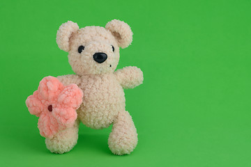 Image showing Knitted toy pink mouse on a green background