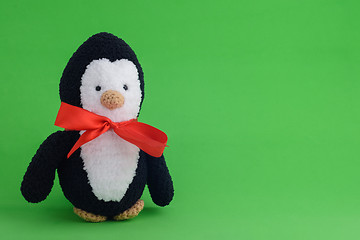 Image showing Knitted toy penguin on a green background