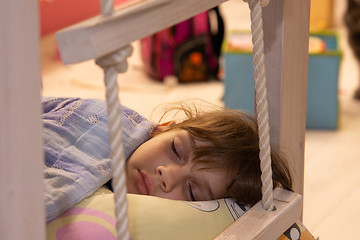 Image showing The girl fell asleep in the light turned on