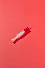 Image showing Disposable syringes of red blood or vaccine with shadows.