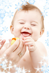 Image showing laughing baby boy in mother hands with rubber duck