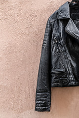 Image showing Black leather jacket on pink wall