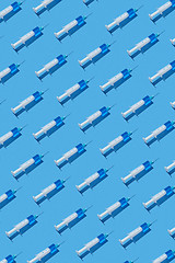 Image showing Medical pattern of disposable syringes with blue injectable liquid.