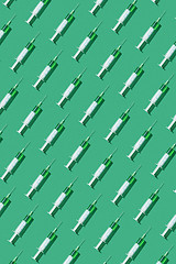 Image showing Vertical pattern from disposabe syrenges with green vaccine.