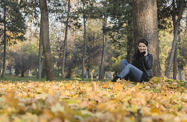 Image showing Woman with a Mobile in a Forest in the Autumn