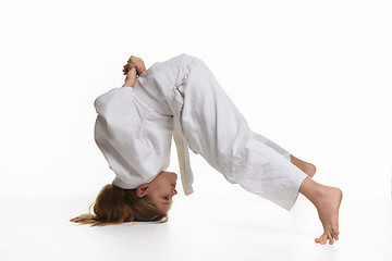 Image showing Girl judo student performs exercise sticking to head and legs