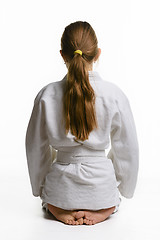 Image showing Girl in judo class, sitting on the floor, rear view