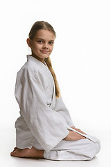 Image showing Girl in judo class, sitting on the floor, the view from the side
