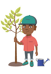 Image showing African-american smiling boy planting a tree.