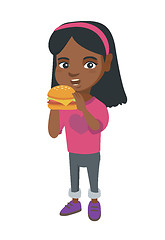 Image showing Little african-american girl eating a hamburger.