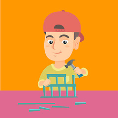 Image showing Boy playing with toy constructor and hammer.