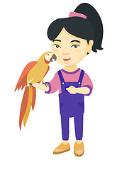 Image showing Asian little girl holding parrot on her hand.