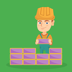 Image showing Caucasian bricklayer boy building a brick wall.