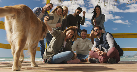 Image showing Group of friends having fun on autumn day at beach