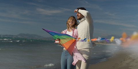 Image showing Happy couple having fun with kite on beach