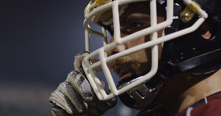 Image showing American Football Player Putting On Helmet on large stadium with