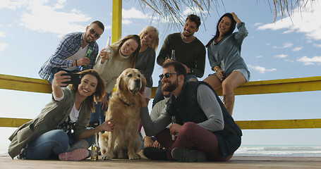 Image showing Group of friends having fun on autumn day at beach