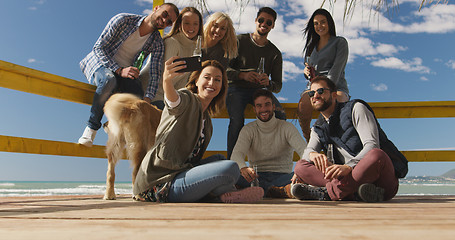 Image showing Group of friends having fun on autumn day at beach